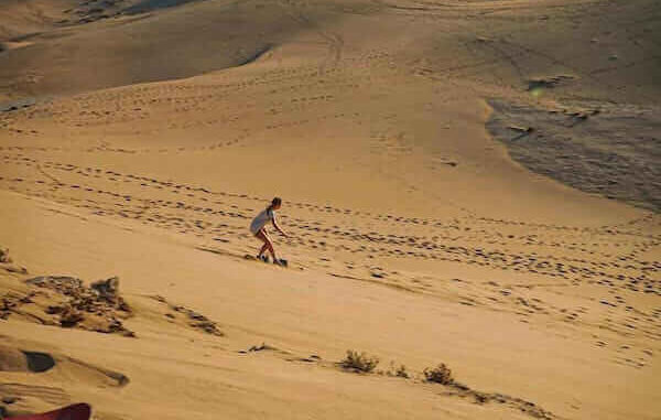 Sandboarding Agadir: An adventure seeker riding the dunes.