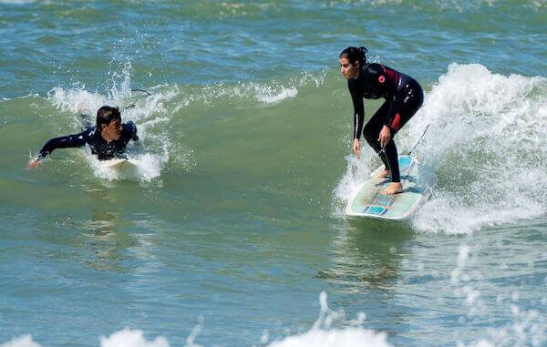 Beginner surfer learning to ride a wave at Crocodile Beach in Agadir