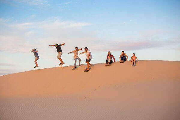 Sandboarding experience in Agadir desert dunes near Timlalin
